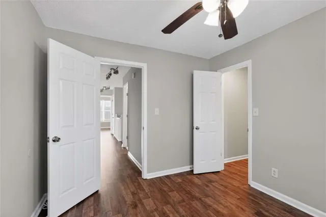 a view of a hallway with wooden floor and chandelier