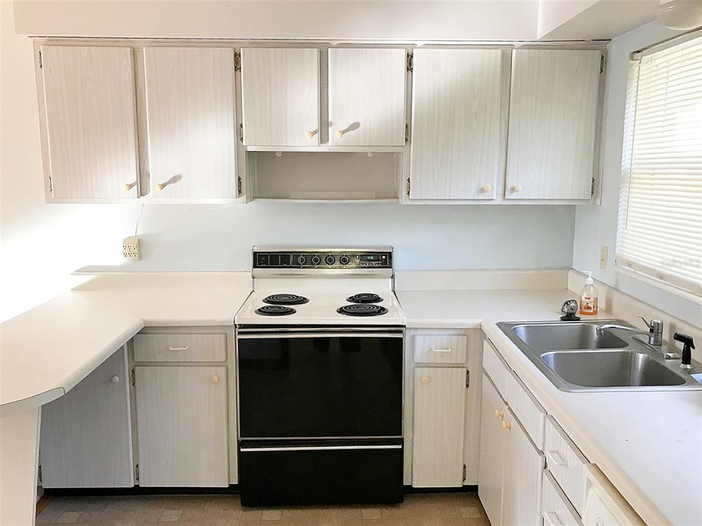 1013 Cody Villa Loop Road Babson Park, FL 33827 - Photo 3 of 6 a kitchen with white cabinets and white appliances