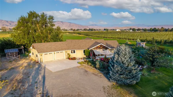 an aerial view of a house with a garden and lake view