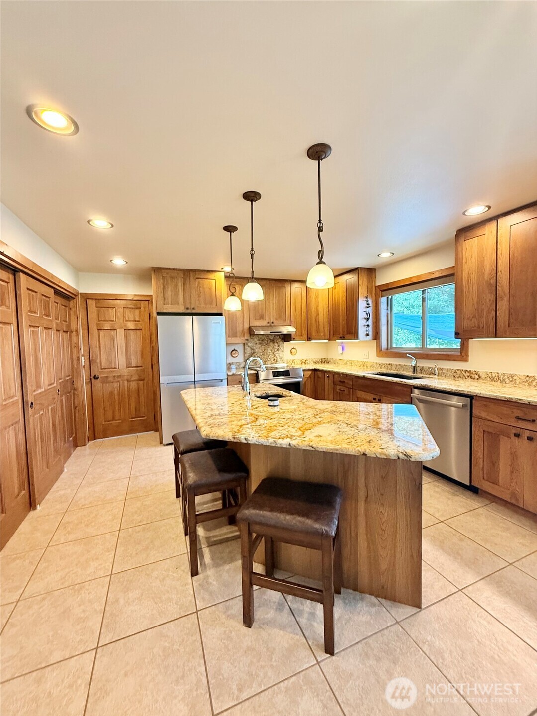 129 Robinson Canyon Road Omak, WA 98841 - Photo 11 of 40 a view of a kitchen with kitchen island stainless steel appliances kitchen island granite countertop a sink and cabinets