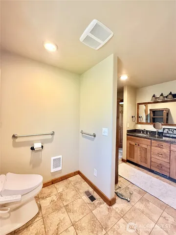 a bathroom with a granite countertop sink a mirror and shower