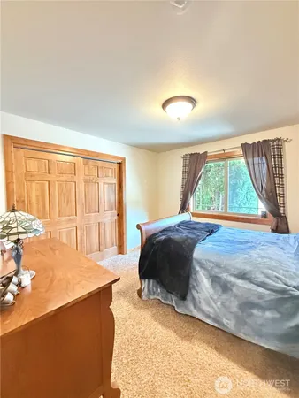 a bedroom with a bed and a large window