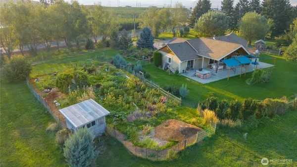 an aerial view of a house with a garden and lake view