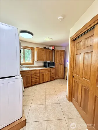 a large white kitchen with a stove a refrigerator and a sink