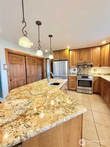 a kitchen with stainless steel appliances kitchen island granite countertop a sink and cabinets