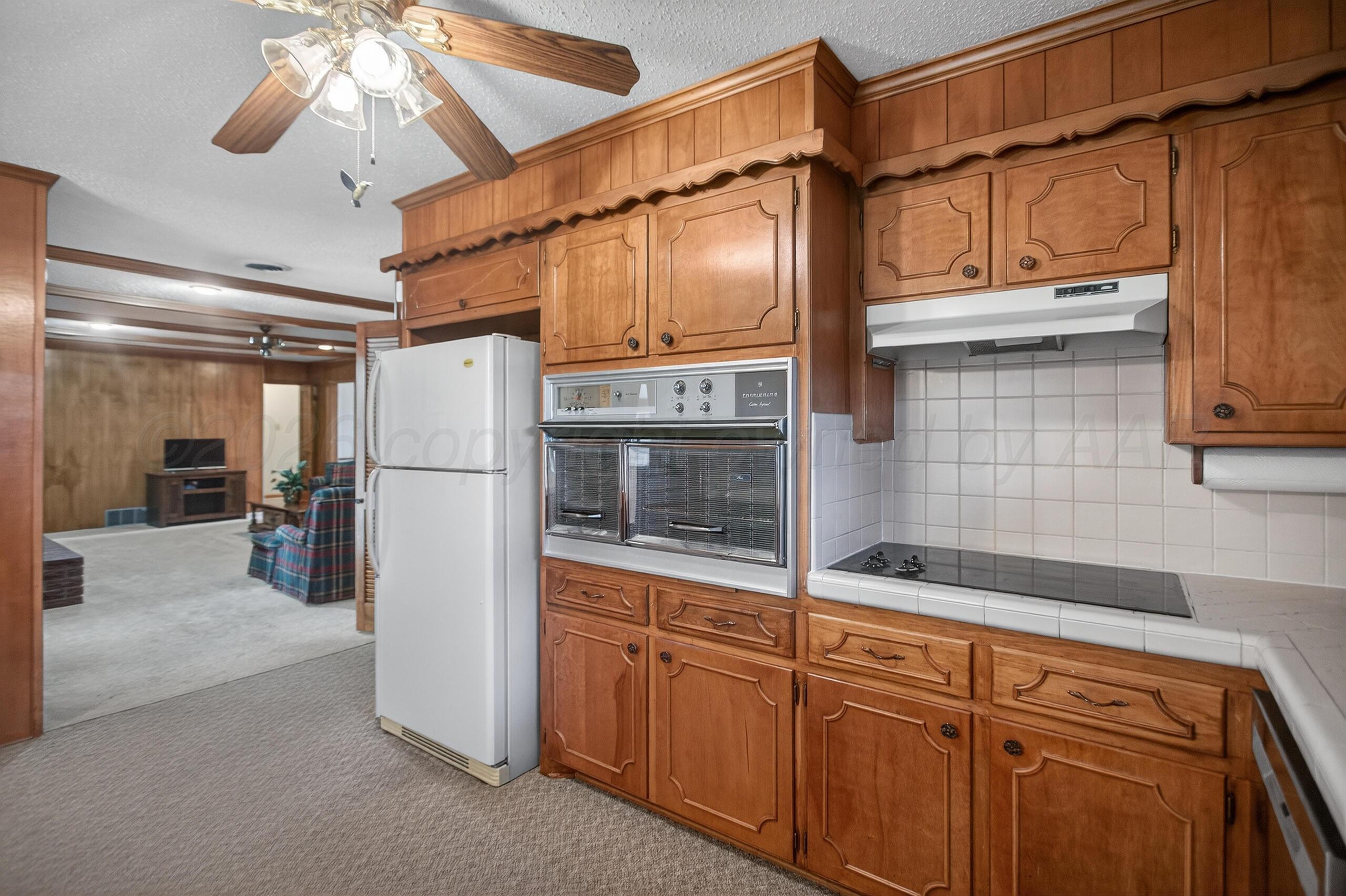 1209 Northwestern Street Perryton, TX 79070 - Photo 15 of 54 a kitchen with refrigerator and window