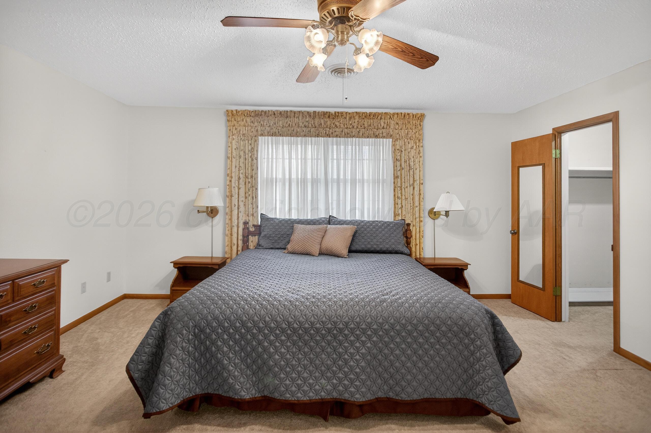 1209 Northwestern Street Perryton, TX 79070 - Photo 28 of 54 a bedroom with a bed and a chandelier