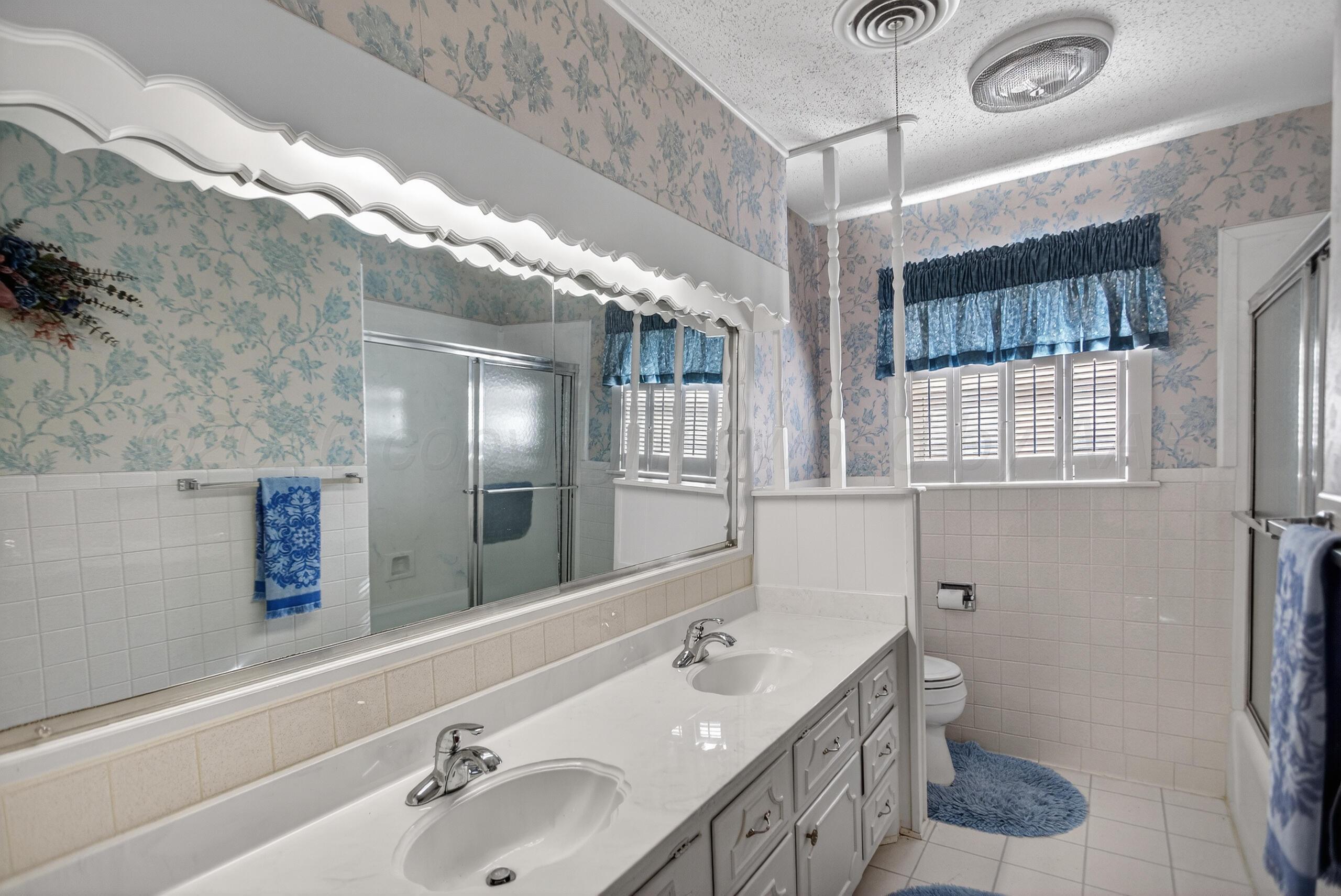 1209 Northwestern Street Perryton, TX 79070 - Photo 37 of 54 a bathroom with a double vanity sink toilet and a mirror