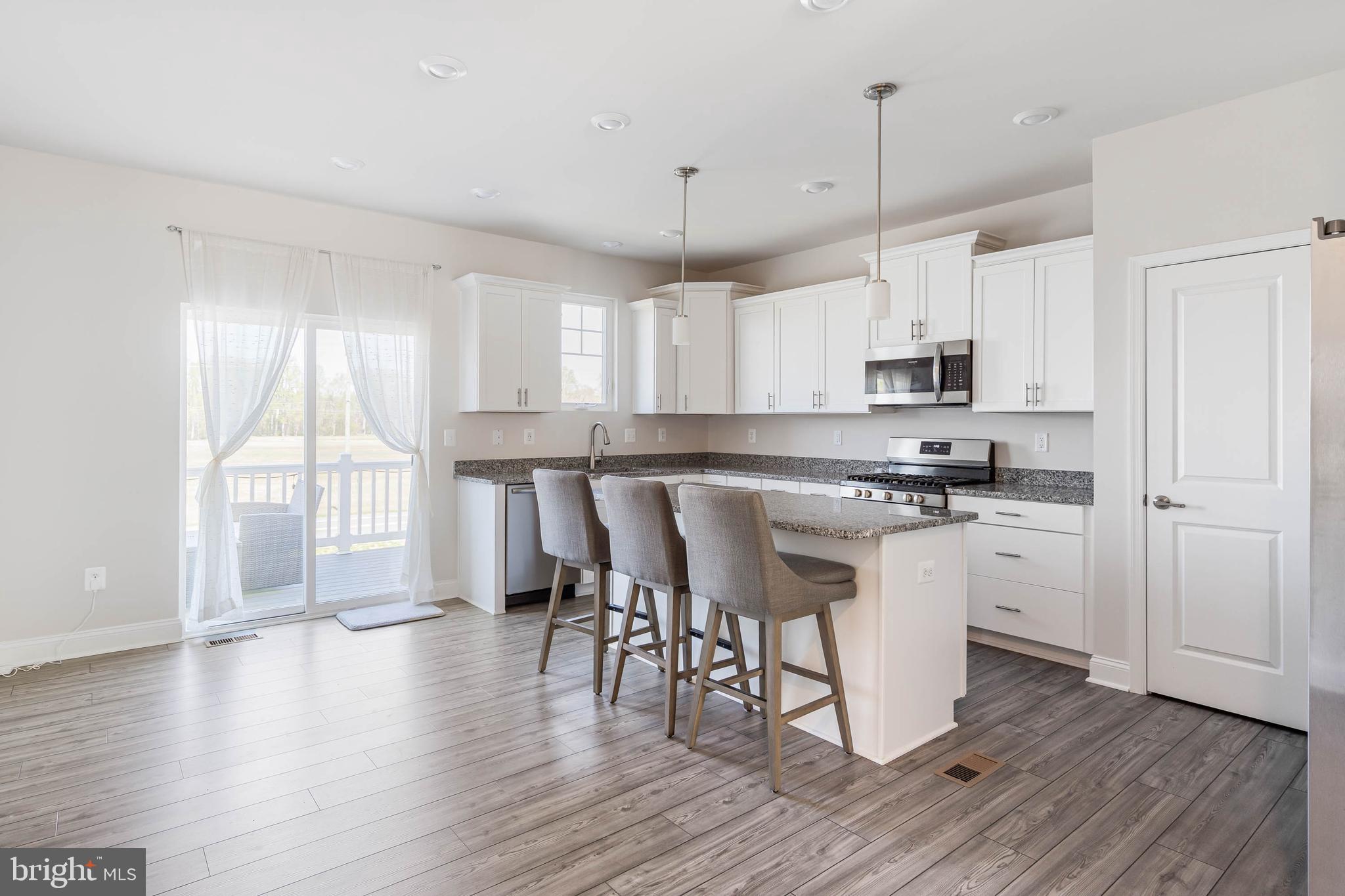 35303 Wright Way Millsboro, DE 19966 - Photo 7 of 26 a kitchen with white cabinets stainless steel appliances and sink