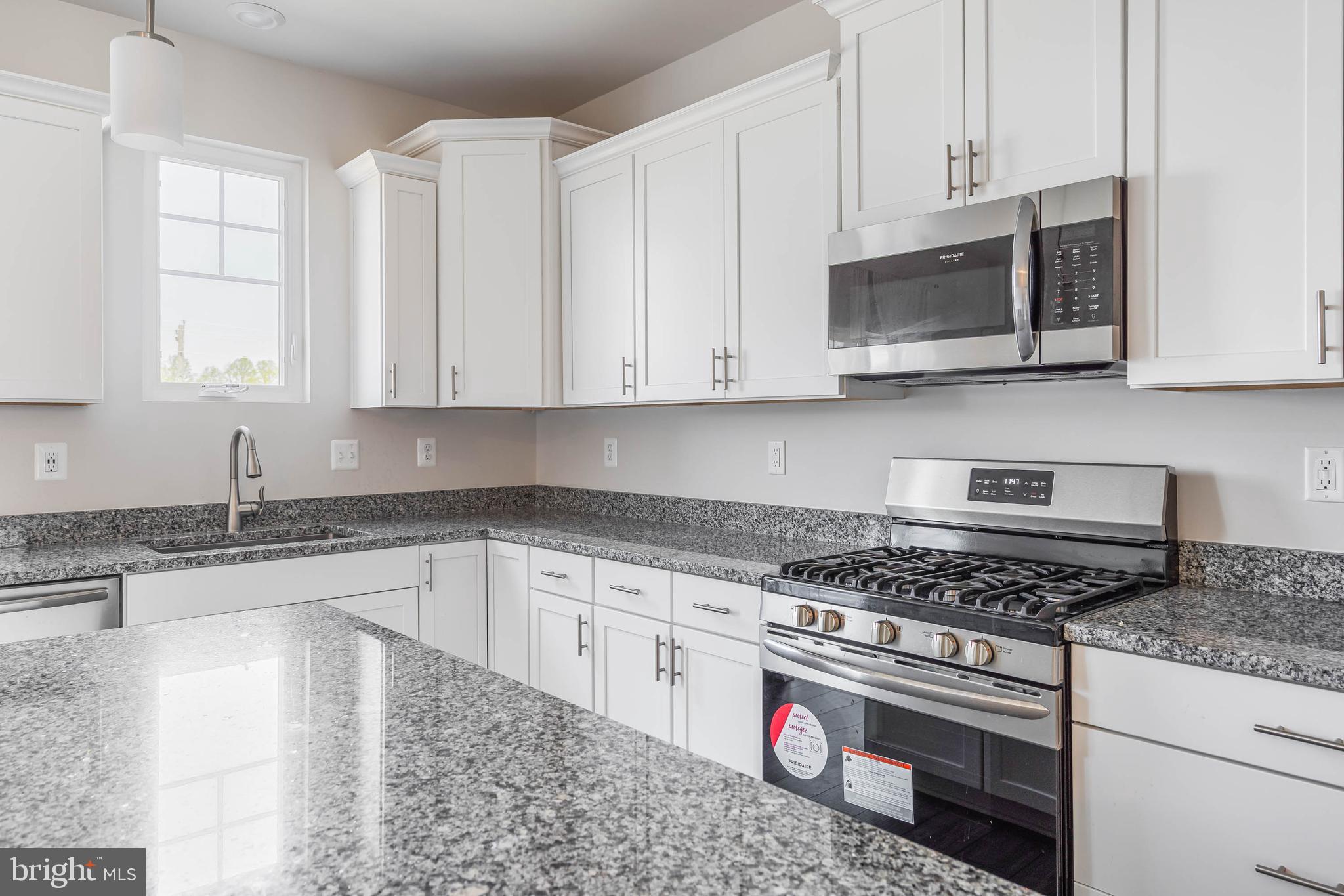 35303 Wright Way Millsboro, DE 19966 - Photo 10 of 26 a kitchen with stainless steel appliances granite countertop white cabinets a stove a sink and dishwasher