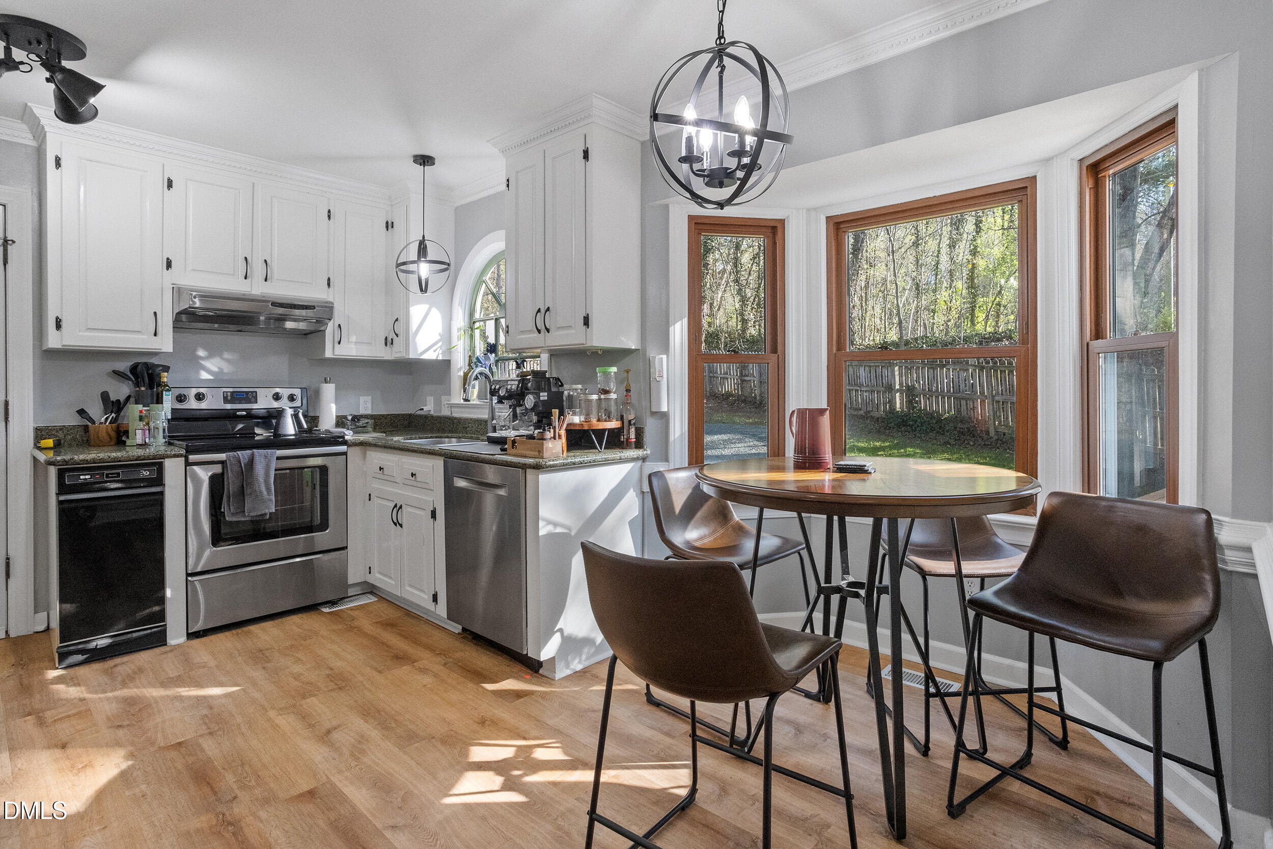 105 Barrett Place Durham, NC 27713 - Photo 17 of 25 a kitchen with stainless steel appliances granite countertop a stove a sink a refrigerator a stove a dining table and chairs with wooden floor