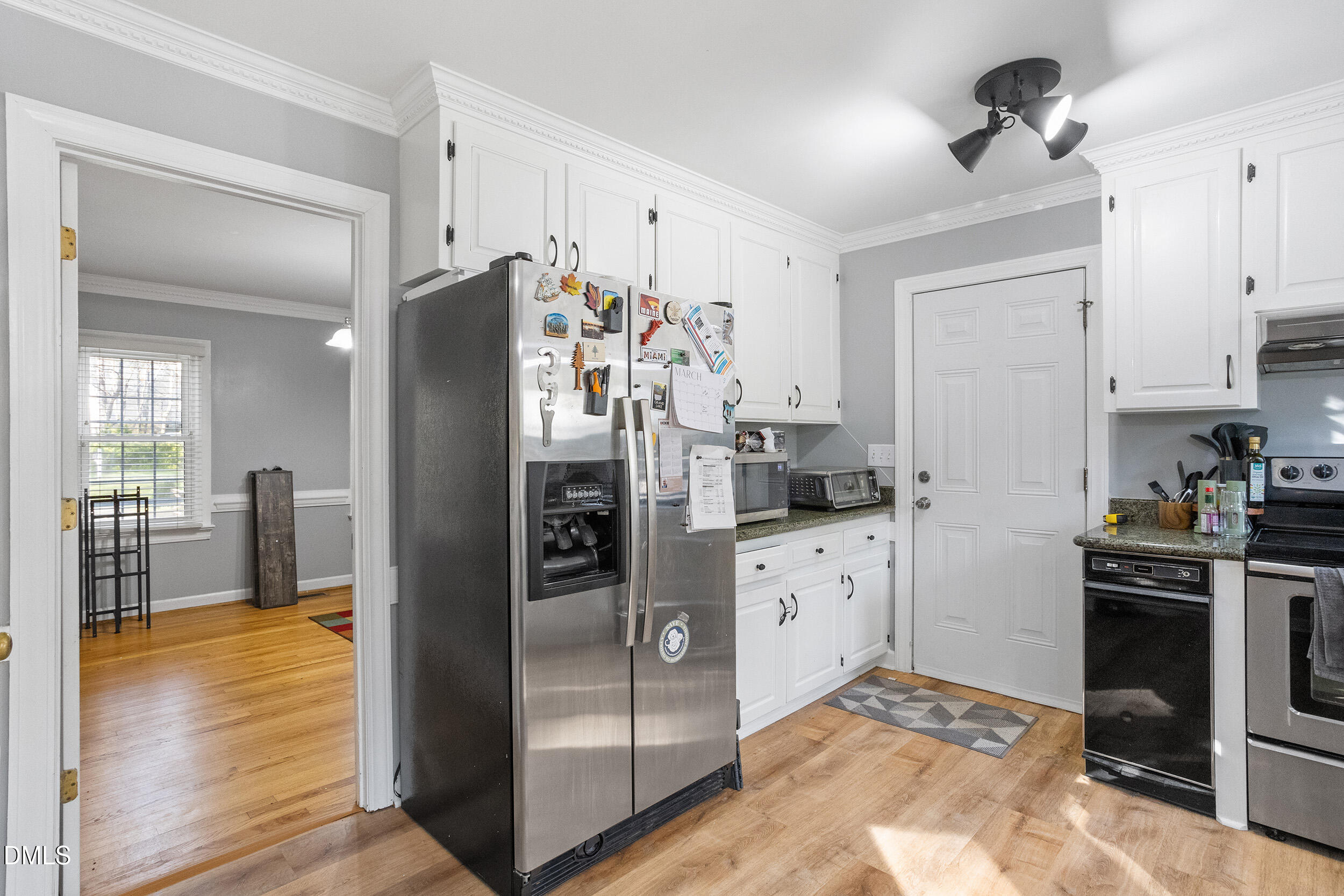 105 Barrett Place Durham, NC 27713 - Photo 20 of 25 a kitchen with stainless steel appliances granite countertop a refrigerator a stove and white cabinets with wooden floor