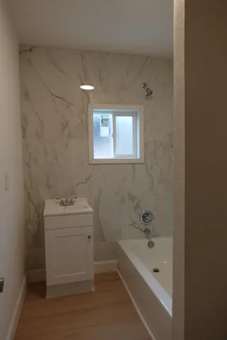 a bathroom with a tub sink toilet and mirror