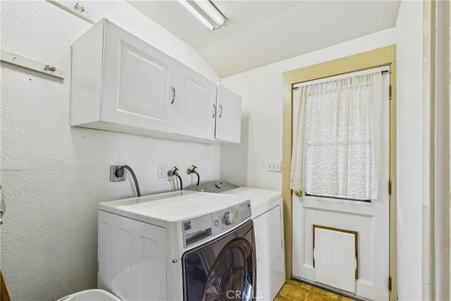 a view of a storage and utility room with dryer and washer