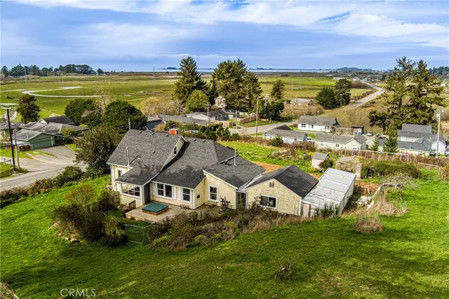 an aerial view of residential houses with outdoor space and ocean view