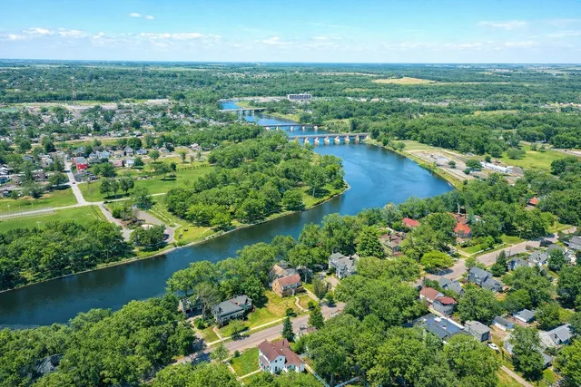 an aerial view of residential houses with outdoor space and trees