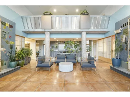 a living room with furniture a floor to ceiling window and potted plants