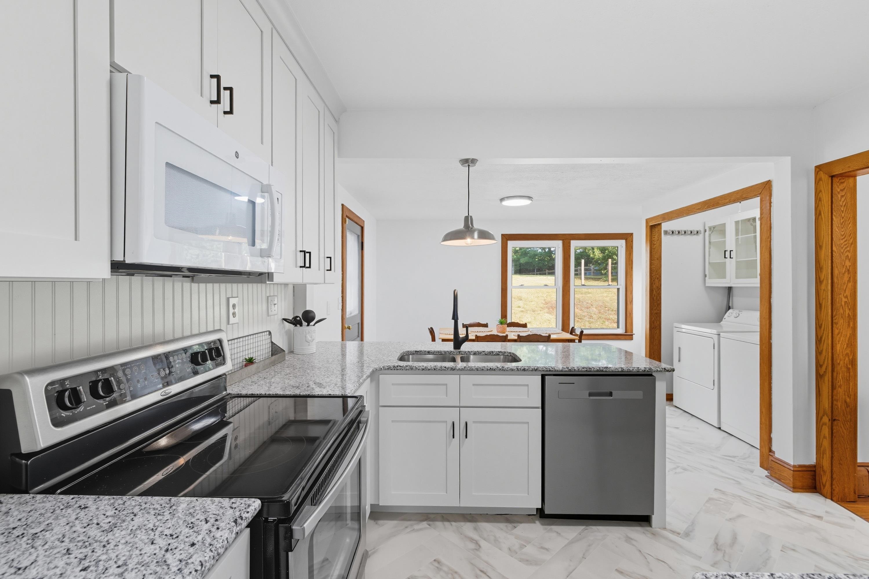3138 Cross Keys Road Harrisonburg, VA 22801 - Photo 6 of 74 The large kitchen in the home features white wooden cabinets, granite counter-tops, eat-up breakfast bar area, and luxury vinyl tile throughout. This kitchen also features stainless steel appliances.