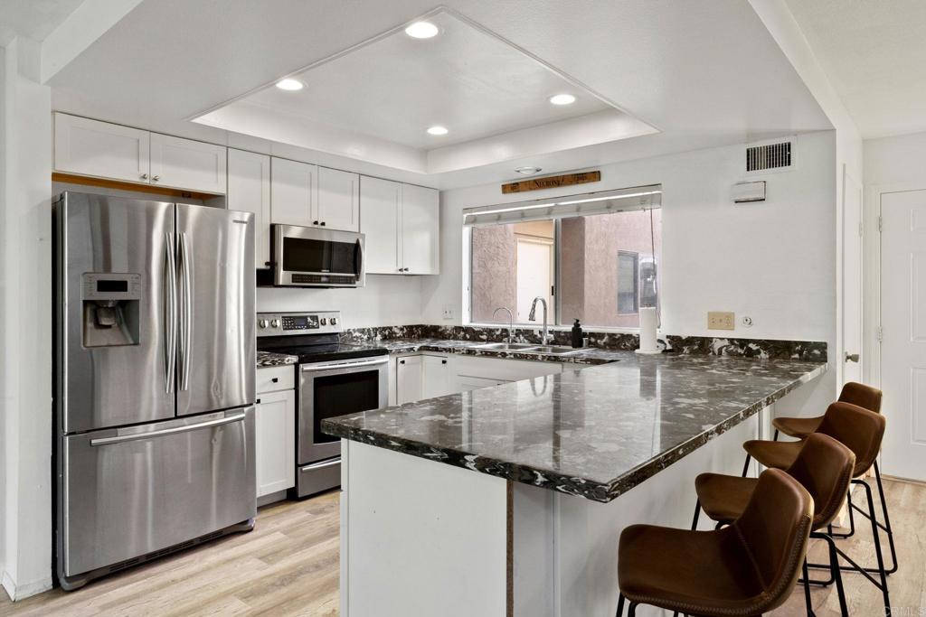 a kitchen with center island a counter space stainless steel appliances and cabinets