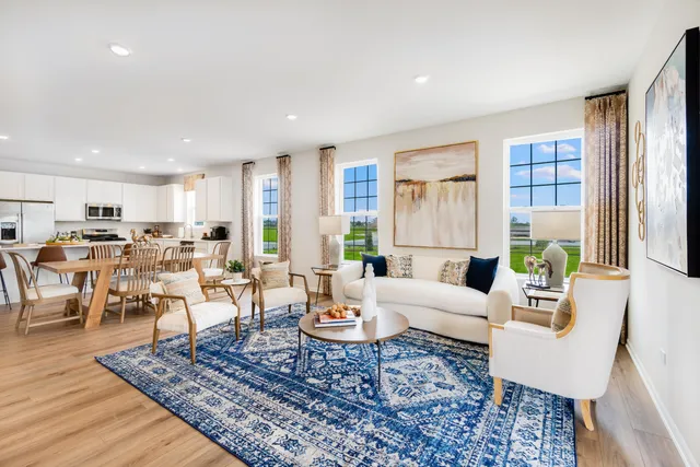 a living room with furniture large window and wooden floor