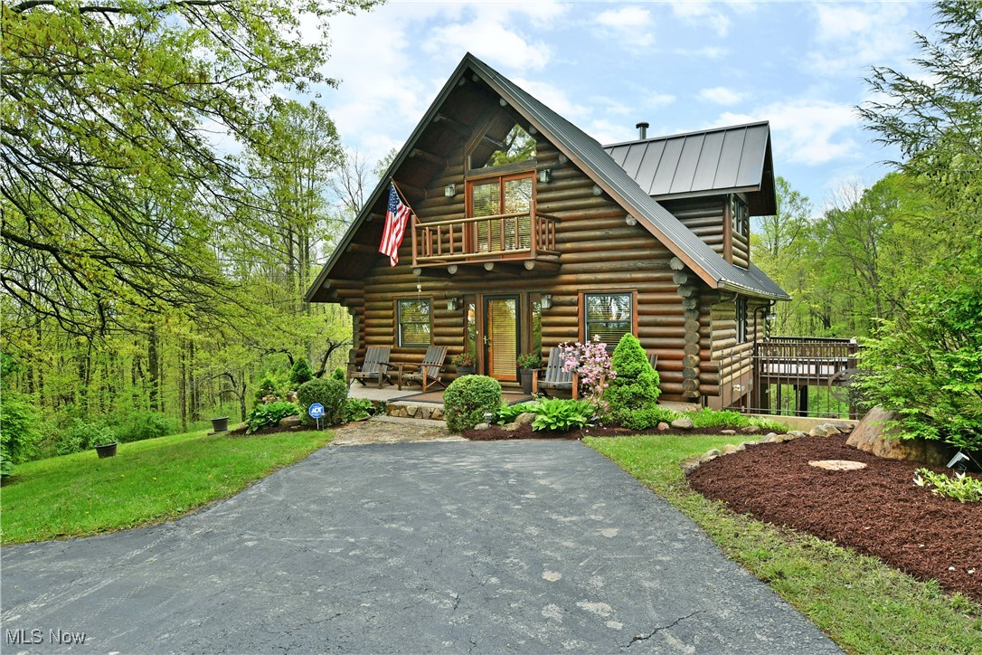 18102 Owen Road Middlefield, OH 44062 - Photo 1 of 50 Log-style house featuring log siding, covered porch, a balcony, and metal roof