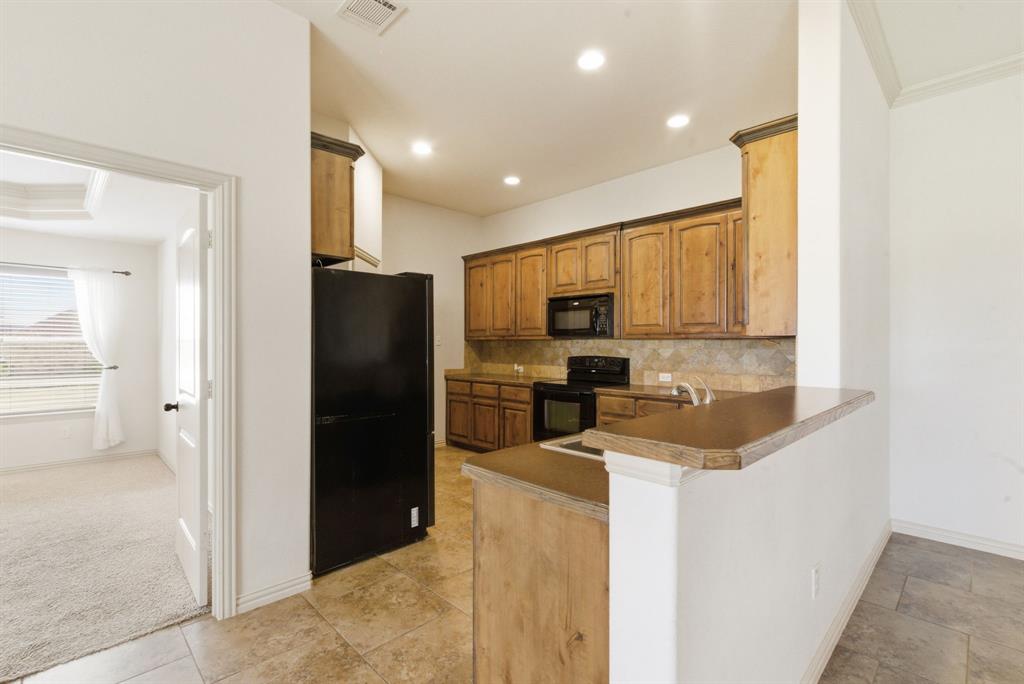 119 Cooperstown Drive Springtown, TX 76082 - Photo 12 of 33 a kitchen with stainless steel appliances granite countertop a refrigerator a stove and a sink