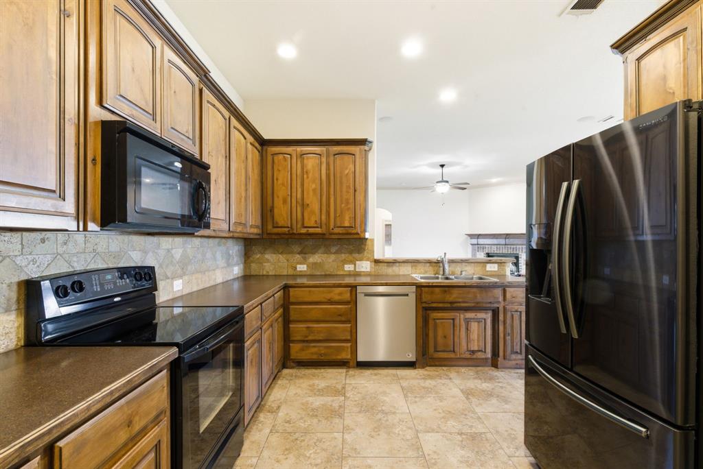 119 Cooperstown Drive Springtown, TX 76082 - Photo 7 of 33 a kitchen with stainless steel appliances granite countertop a refrigerator a stove and a sink