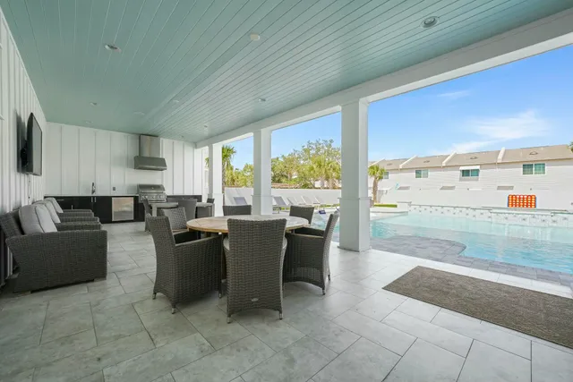 a dining hall with stainless steel appliances kitchen island granite countertop a table chairs and a refrigerator