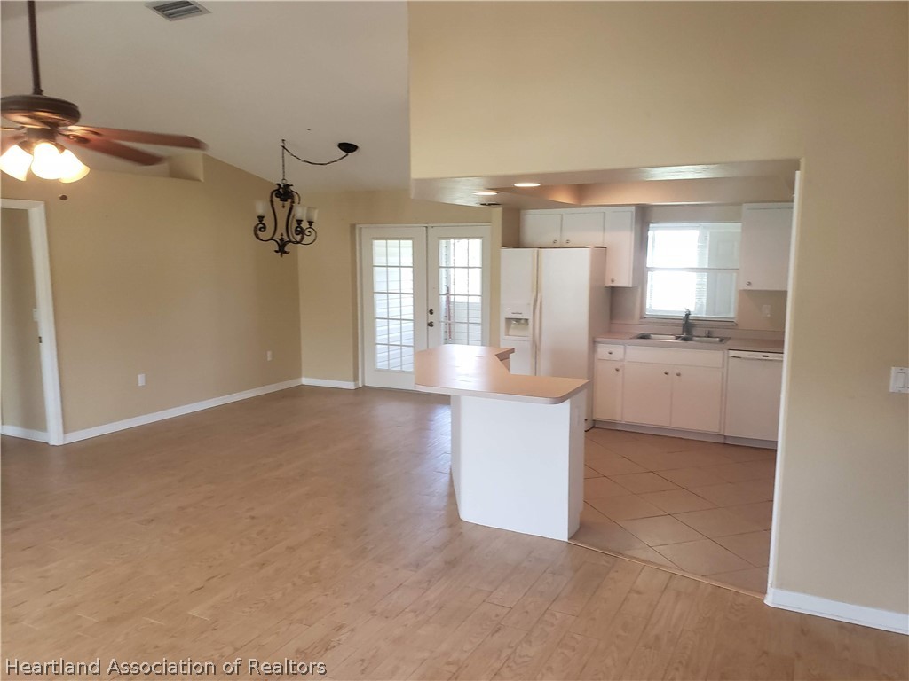4243 Mandarin Road Sebring, FL 33875 - Photo 8 of 12 a large white kitchen with a white countertops a sink and dishwasher