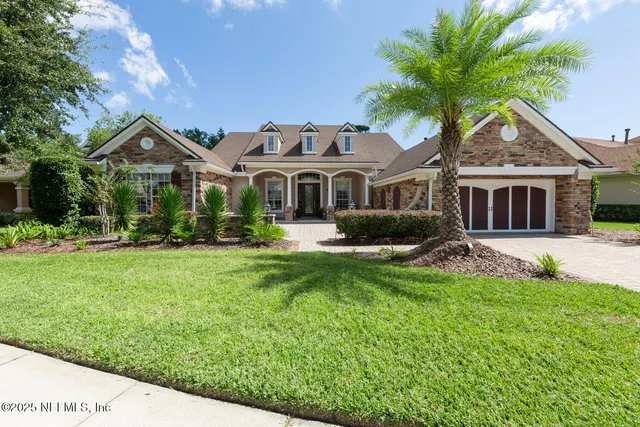 a front view of a house with a yard and palm tree
