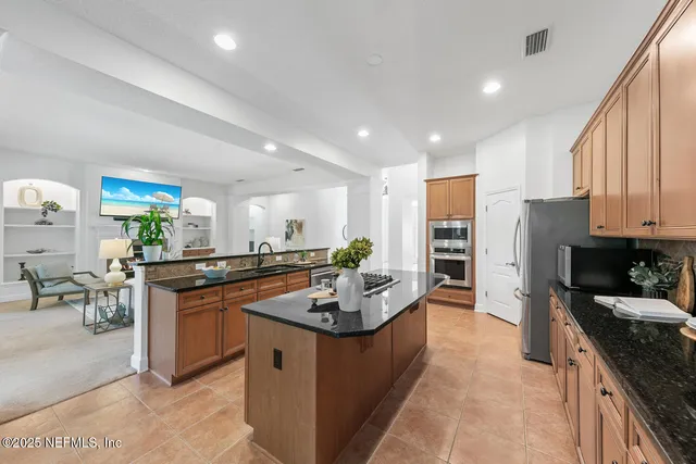 a living room with furniture and a view of kitchen