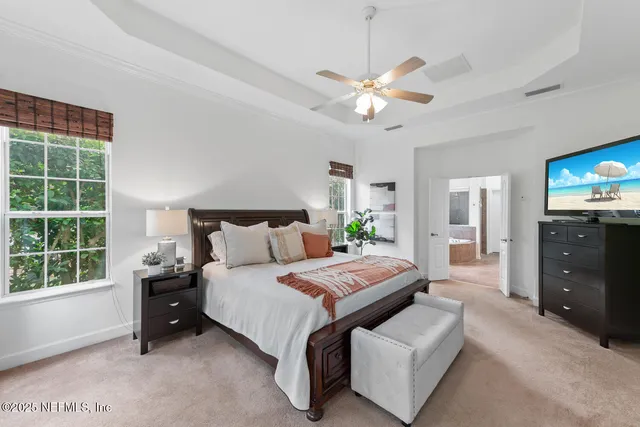 a bedroom with a bed and a flat tv screen on dresser