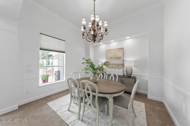 a kitchen with stainless steel appliances a sink a stove a refrigerator cabinets and a dining table