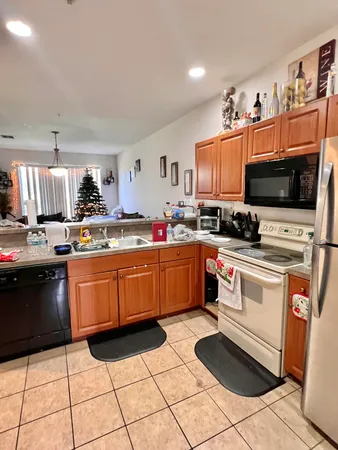 a kitchen with stainless steel appliances a stove top oven a sink a counter top space and cabinets
