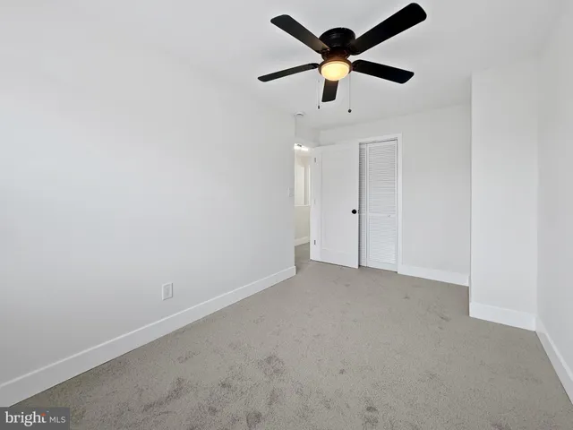an empty room with a ceiling fan and a ceiling fan
