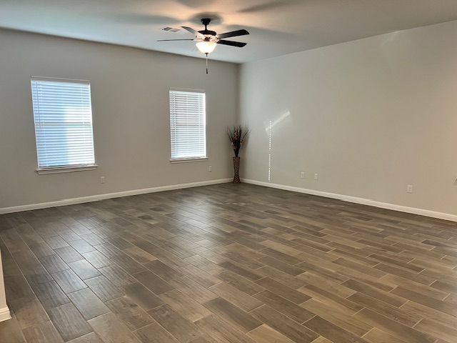 221 Arabian Colt Drive Georgetown, TX 78626 - Photo 11 of 36 an empty room with wooden floor chandelier fan and windows