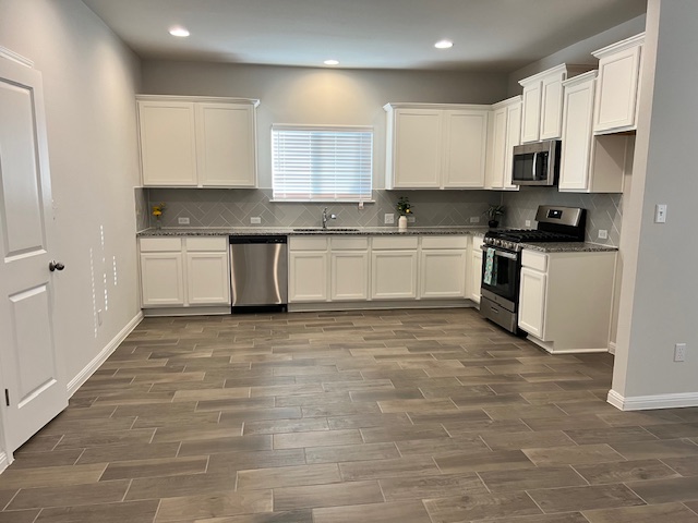 221 Arabian Colt Drive Georgetown, TX 78626 - Photo 8 of 36 a kitchen with granite countertop a stove top oven sink and cabinets