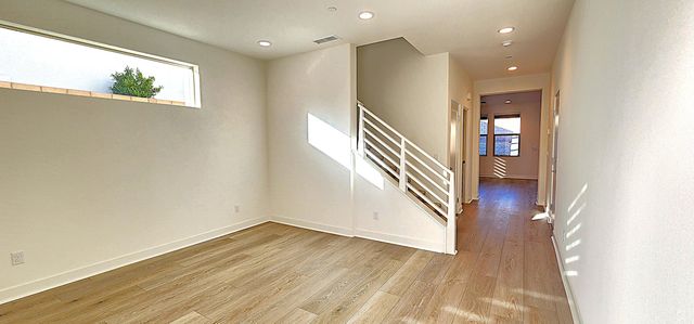 a view of a hallway with wooden floor and staircase
