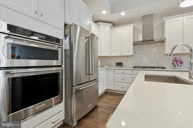 a kitchen with white cabinets and stainless steel appliances