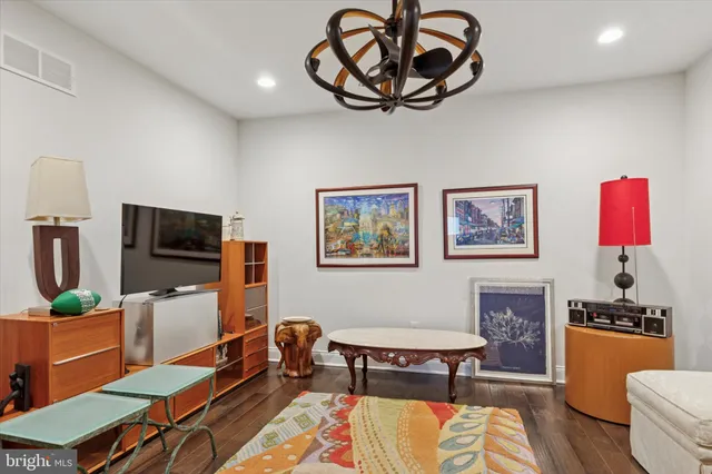 a living room with furniture a flat screen tv and a table