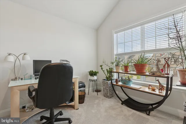 a view of a workspace with furniture and a window