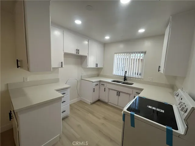 a kitchen with a sink appliances and cabinets