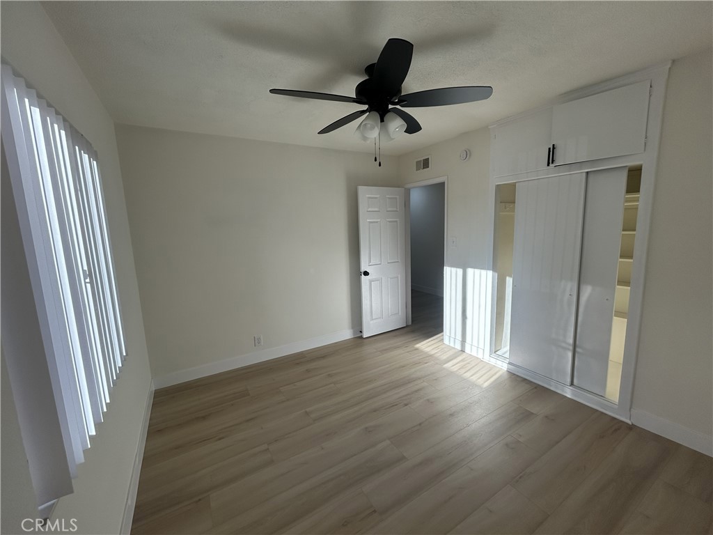 2361 Faust Avenue Long Beach, CA 90815 - Photo 9 of 20 a view of an empty room with wooden floor and a ceiling fan