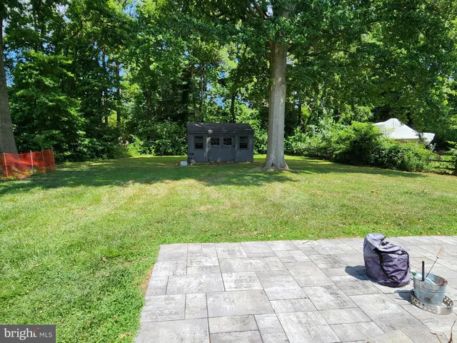 a backyard of a house with lots of green space and fountain