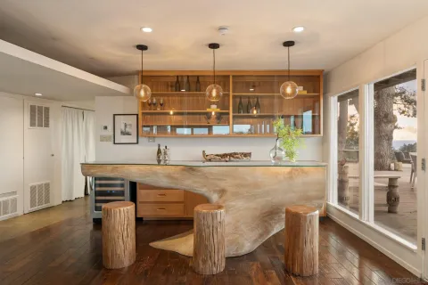 a view of kitchen with stainless steel appliances granite countertop dining table chairs sink and wooden floor