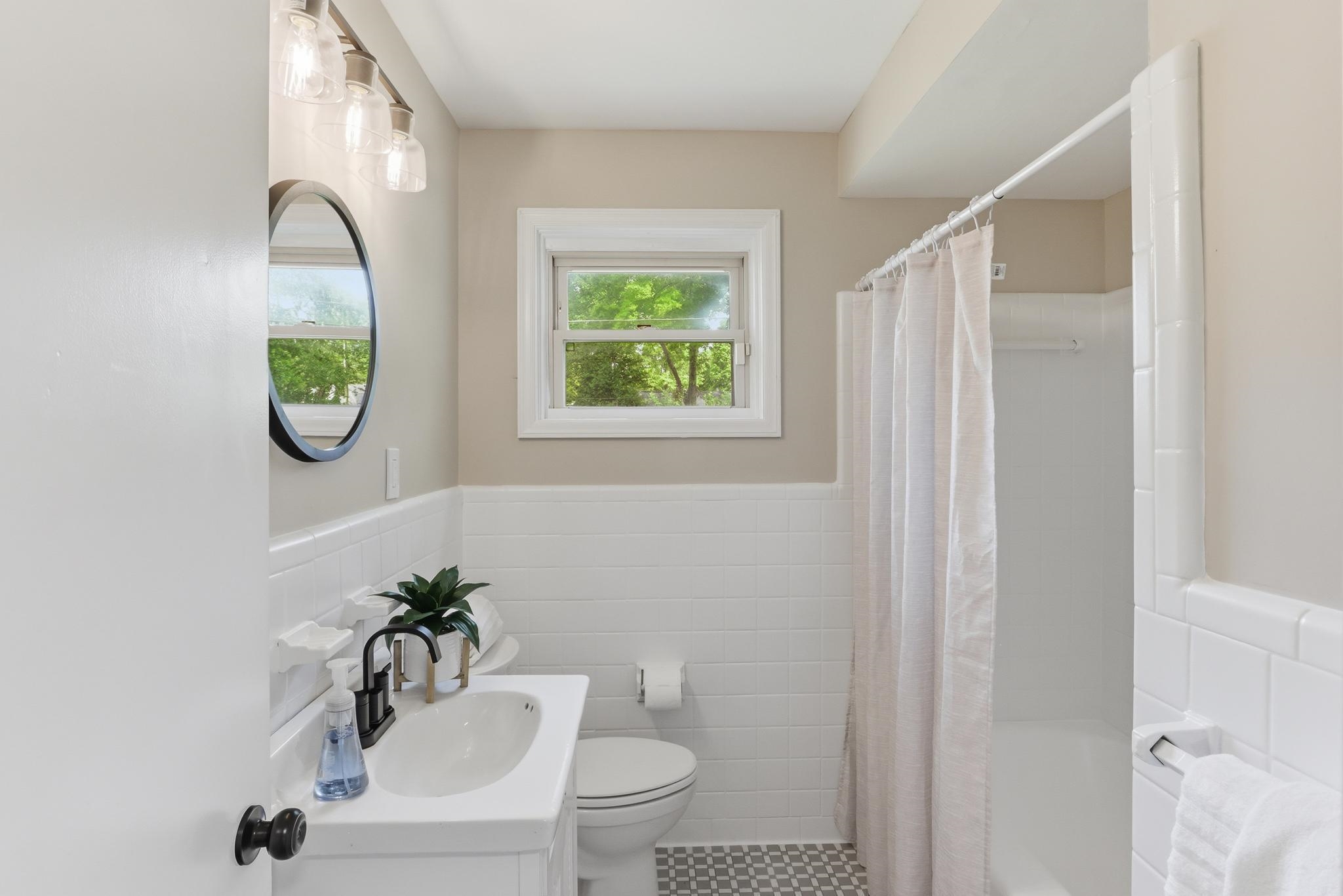 312 Fernway Road Memphis, TN 38117 - Photo 27 of 38 Bathroom with vanity, wainscoting, tile walls, and shower / bath combination with curtain