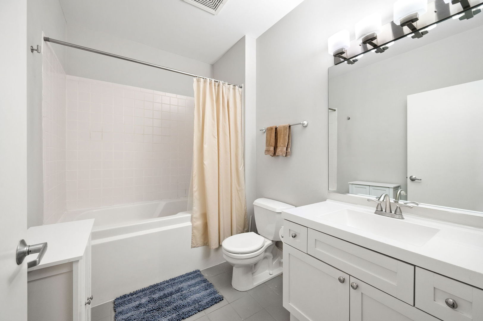 1301 West Madison Street, Unit 207 Chicago, IL 60607 - Photo 12 of 17 a bathroom with a sink toilet a shower and a mirror