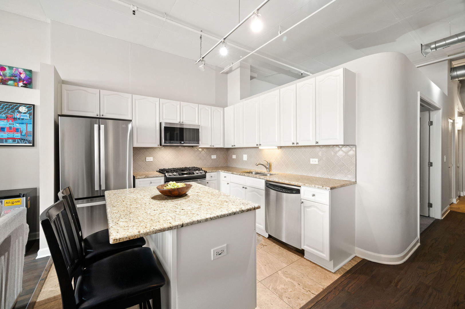 1301 West Madison Street, Unit 207 Chicago, IL 60607 - Photo 3 of 17 a kitchen with stainless steel appliances granite countertop a refrigerator a stove a sink dishwasher and white cabinets with wooden floor