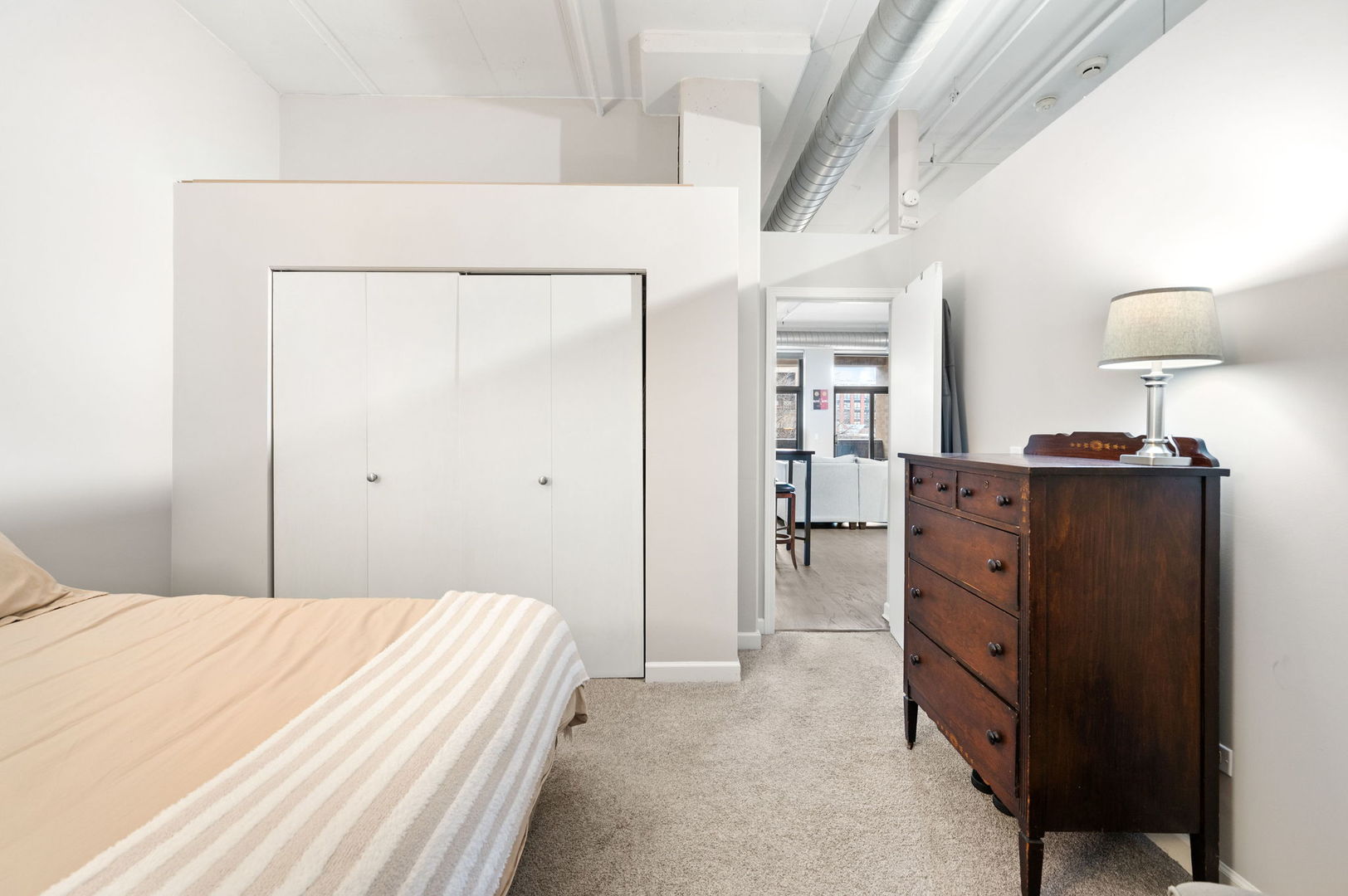 1301 West Madison Street, Unit 207 Chicago, IL 60607 - Photo 9 of 17 a bed room with a bed and a dresser