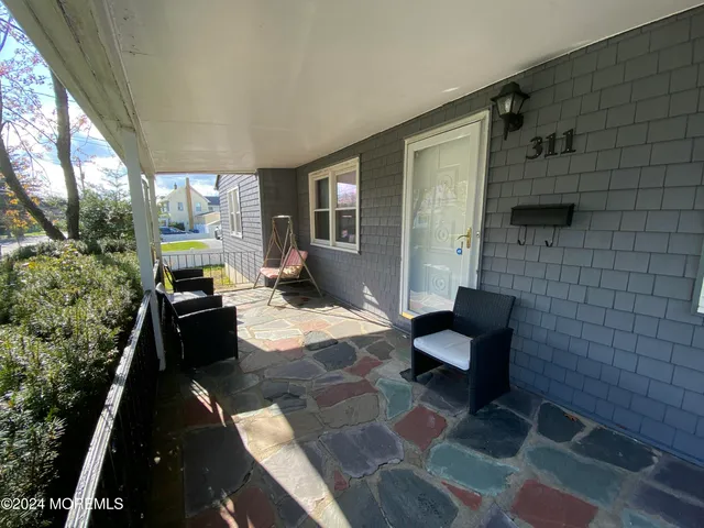a view of a patio with a table and chairs under an umbrella